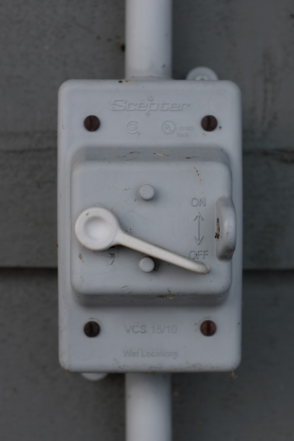 A grey plastic box marked on-off with a switch faded almost to white.